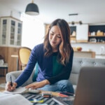 Woman reviewing her finances in her living room.
