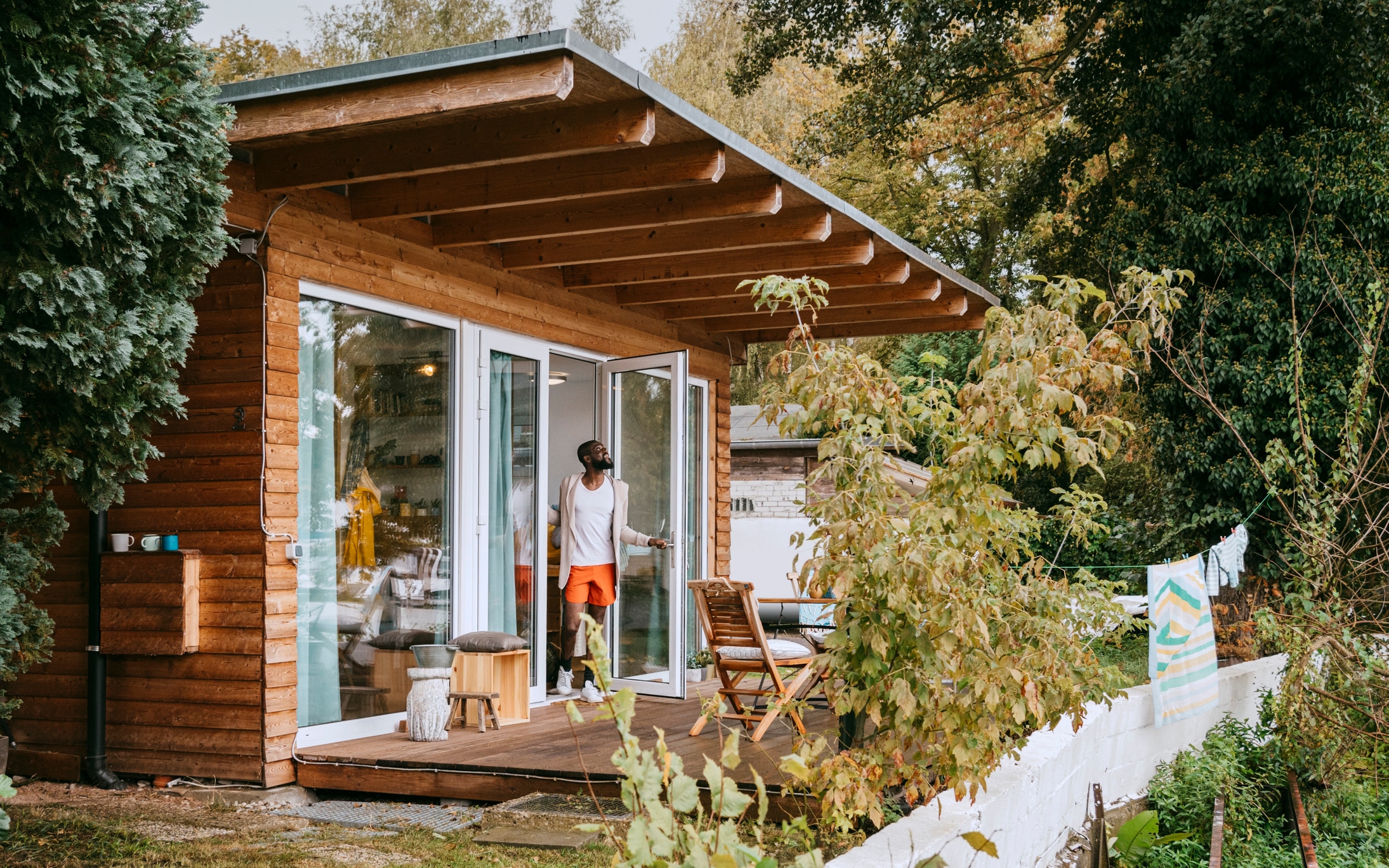 Mature man standing at doorway of tiny house