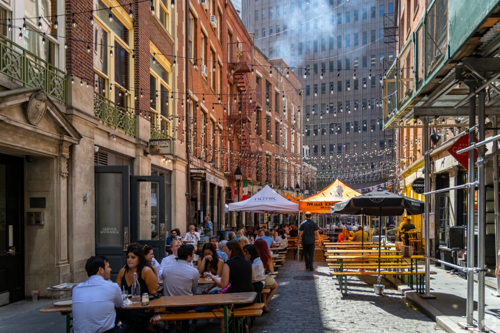 People dining outdoors in a historic area of the financial district in Manhattan, New York.