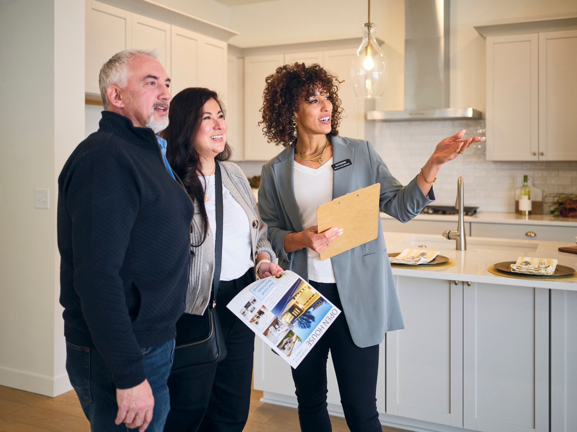 A professional real estate agent, showing a home to prospective buyers at an open house.