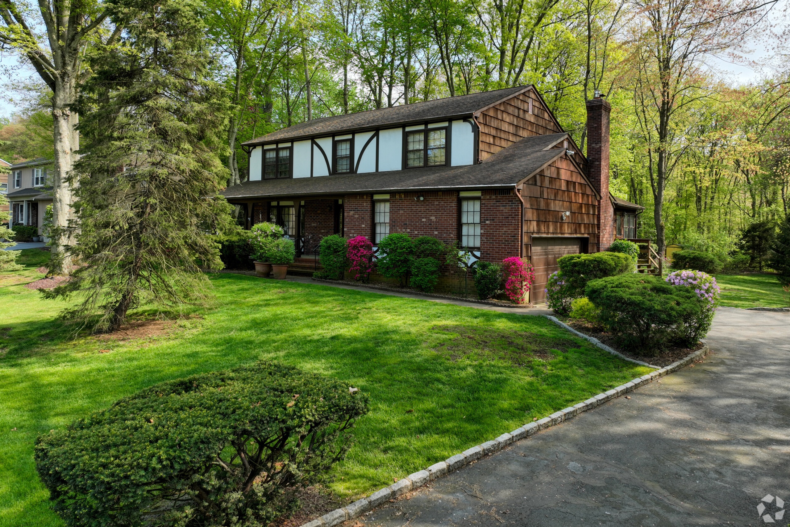 A single family, tudor style house and front yard in New Monmouth, New Jersey.